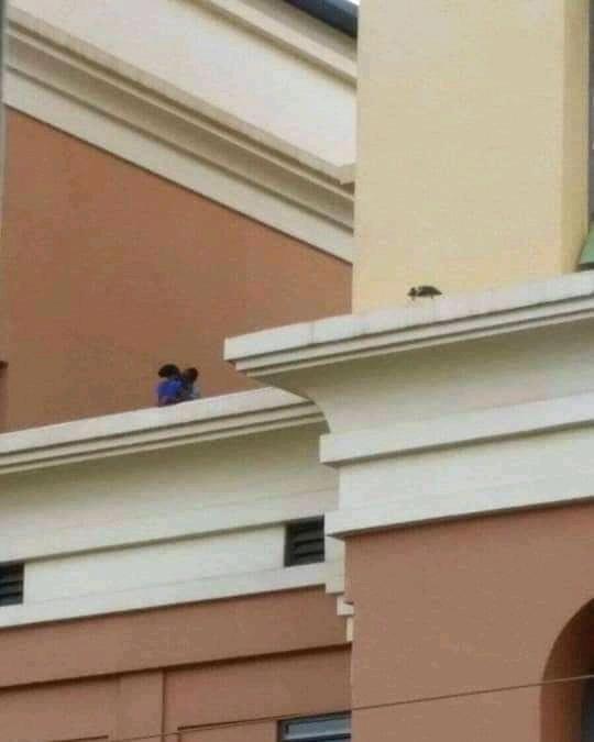 Two people kiss passionately on top of Acacia Mall in Kampala