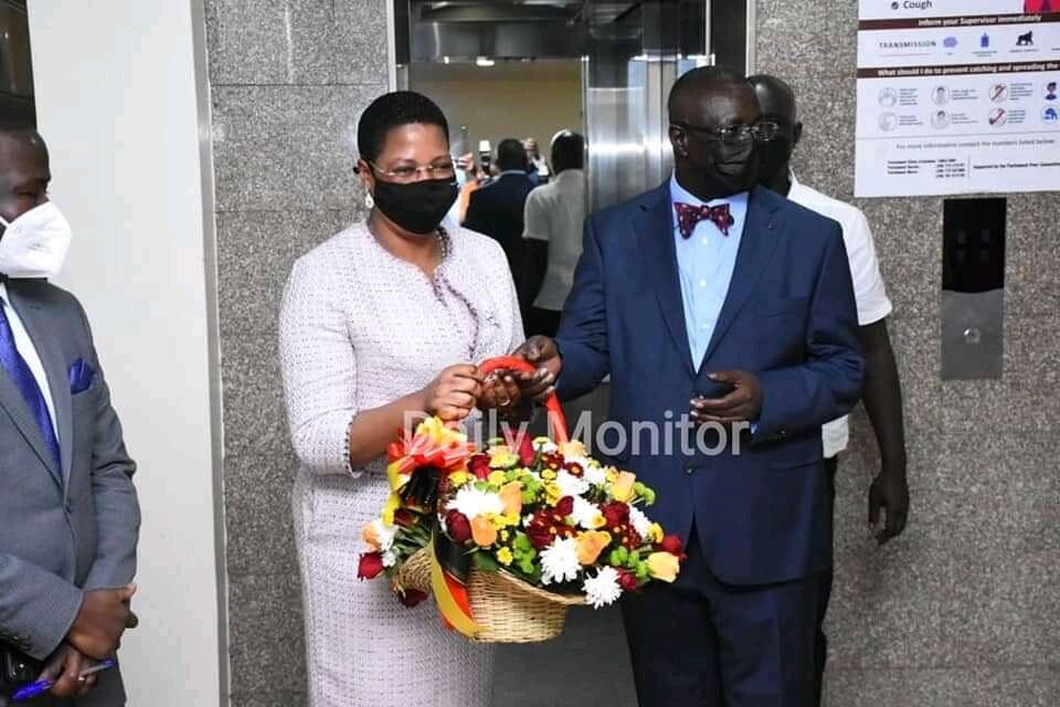 Deputy speaker, Betty Amongi hands Oulanyah a bouquet of flowers to welcome him back 