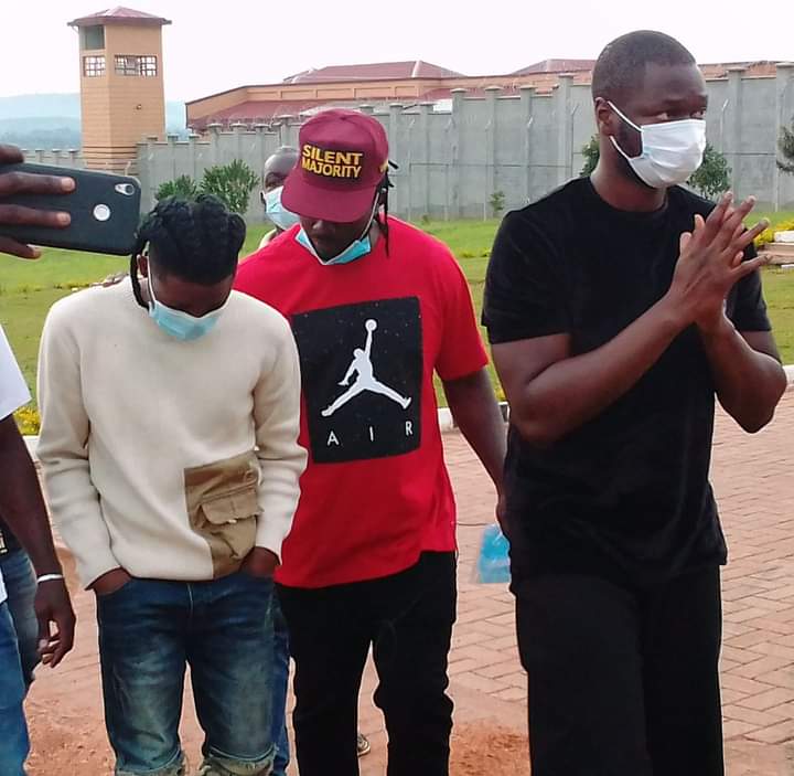 Omah Lay (left) and Bebe Cool (in red) walk out of Kitalya prison, Uganda