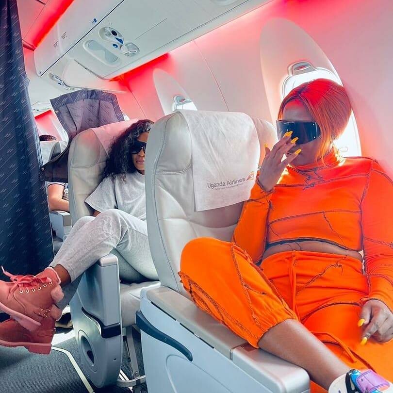 Karole Kasita and Lydia Jazmine (in orange) aboard Uganda airlines